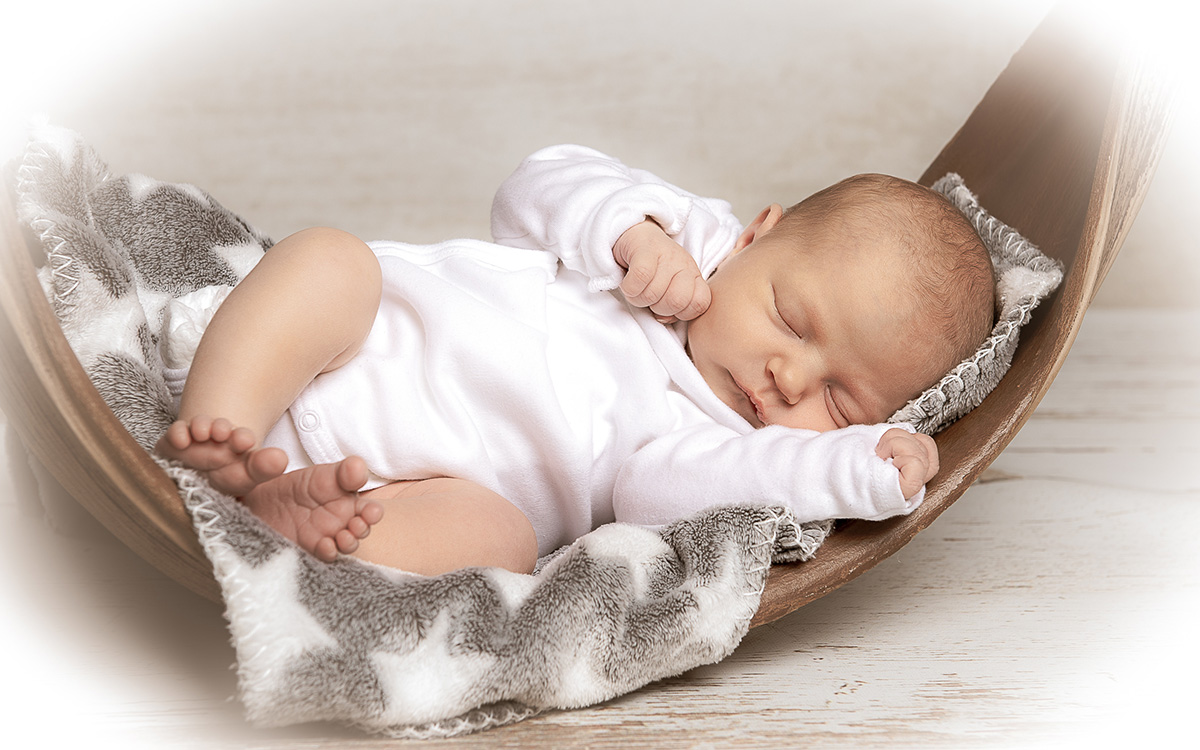 Bild eines schlafenden Babys in einer Decke eingewickelt.